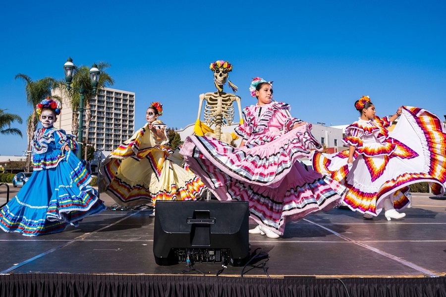 girls dancing on stage wearing catrina costumes