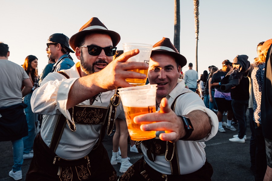 two guys holding cups with beers in Oktoberfest