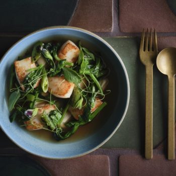 food in a bowl with spoon and fork