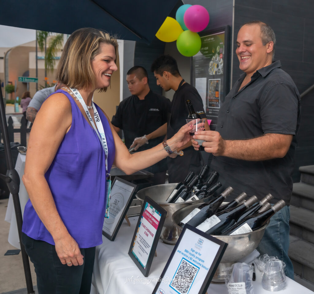 man handing a woman a glass of wine