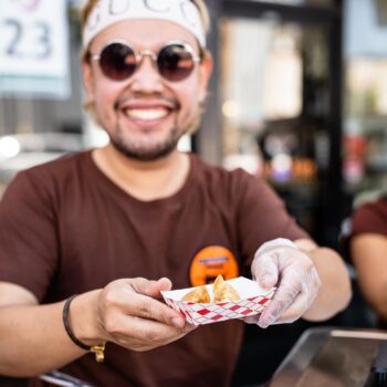 man holding a small paper plate with food
