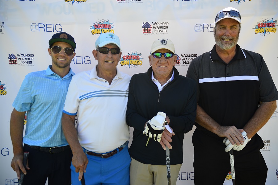 four men standing side by side with golf clubs