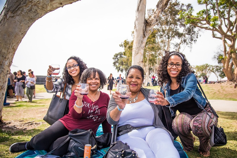 ladies sitting on the grassy lawn drinking wine at the Uncorked Wine Festivals