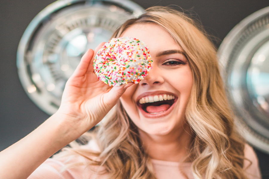 girl holding a donut to her face