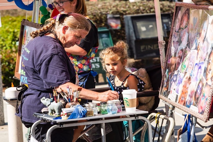 a woman and a little girl in a street fair