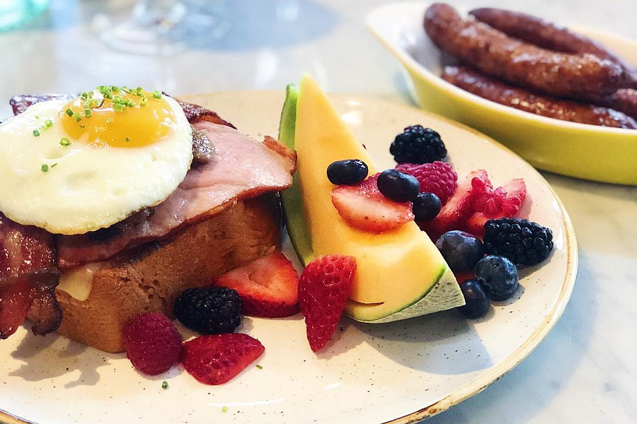 toast with egg on top and fruits on the side