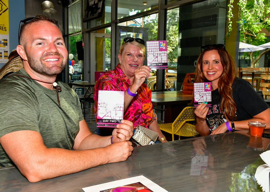 three people holding tickets